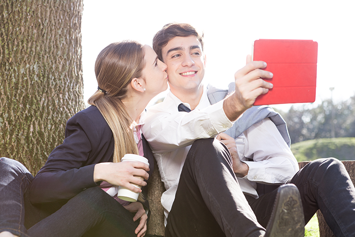 Young couple outdoors taking a selfie, contrasting with the bride walking out after learning groom cheated with her mom. Young couple outdoors taking a selfie, contrasting with the bride walking out after learning groom cheated with her mom.
