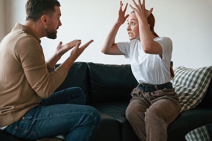 Man and girlfriend having a heated argument on couch after he lends her a spare keyboard, tension rises between the couple. Man and girlfriend having a heated argument on couch after he lends her a spare keyboard, tension rises between the couple.