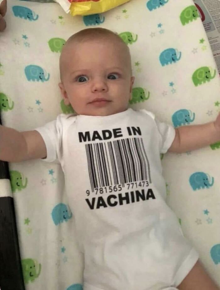 Baby lying on an elephant-patterned blanket wearing a funny "Made in Vachina" onesie, perfect for funny memes brightening dark winter days.