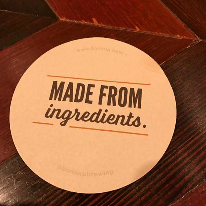 Round beer coaster on wooden table with text made from ingredients funny meme in simple style for winter days.