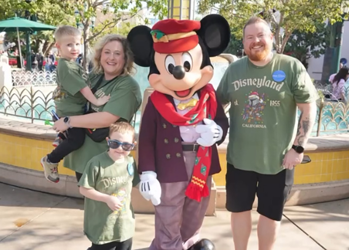 Family with kids posing with Mickey Mouse at Disneyland, related to Hilary Swank apologizes for berating mom of terminally ill kids
