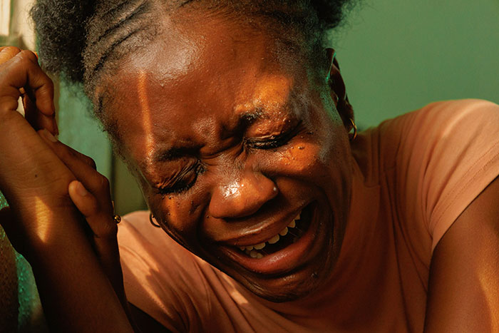 Woman crying intensely indoors, expressing emotional distress, relating to couple breakup over newborn's bizarre name issue.