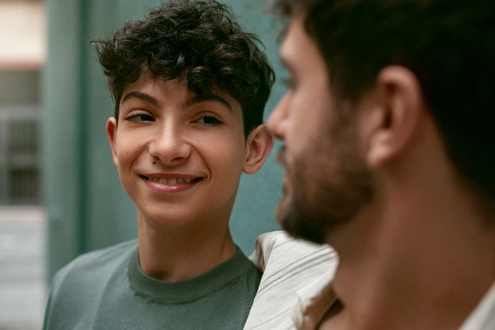 Teen son listens to dad giving dating advice in a casual moment, reflecting old-fashioned 1950s style guidance. Teen son listens to dad giving dating advice in a casual moment, reflecting old-fashioned 1950s style guidance.
