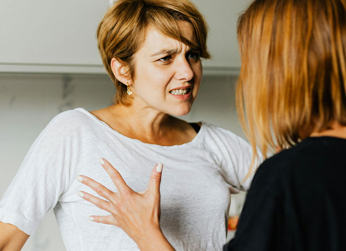 Woman fed up with coworker preaching body positivity while skinny-shaming during heated conversation indoors