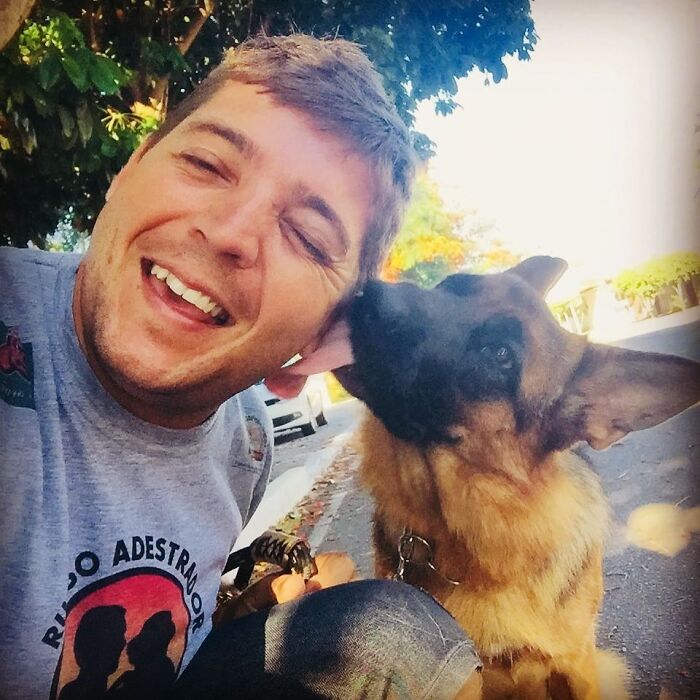 Man smiling outdoors with a German shepherd dog, highlighting a close human and wild vulture bond like a dog with wings Man smiling outdoors with a German shepherd dog, highlighting a close human and wild vulture bond like a dog with wings