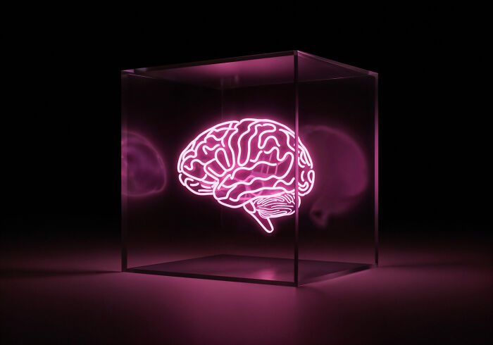 Glowing neon human brain inside a transparent cube, highlighting fascinating human body features in a dark setting.