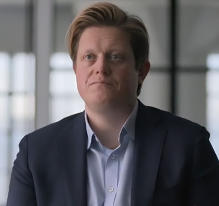 A PR guru in a dark suit sharing insights on why they cut ties with Prince Harry and Meghan Markle in an interview setting.