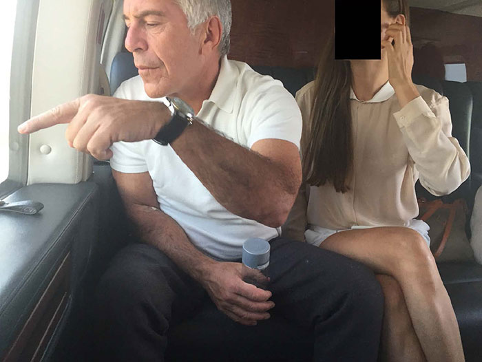 Man in white shirt pointing inside a private plane, with woman sitting beside him partially covering her face in Epstein files photos.