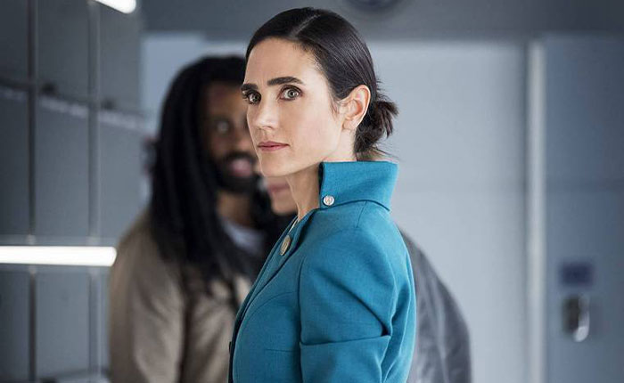 Jennifer Connelly in teal jacket looking serious, relating to iconic movie scene and career regret discussion.