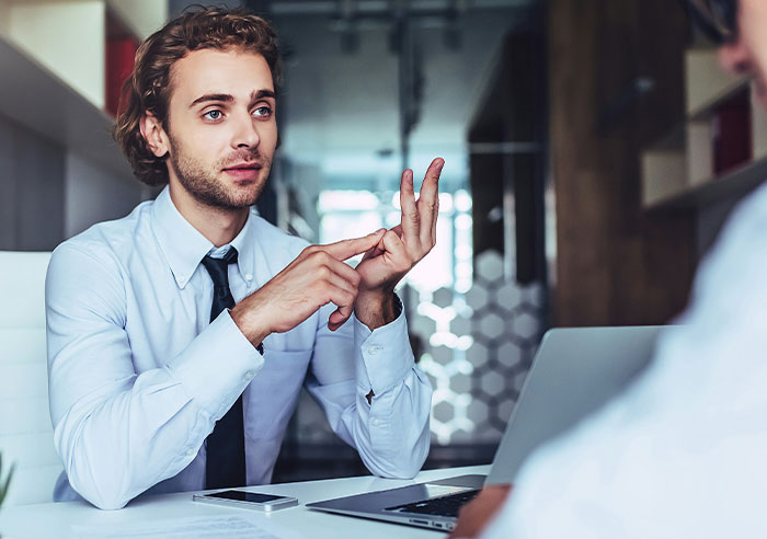 A job candidate asking mental questions to a recruiter during an interview in a modern office setting.
