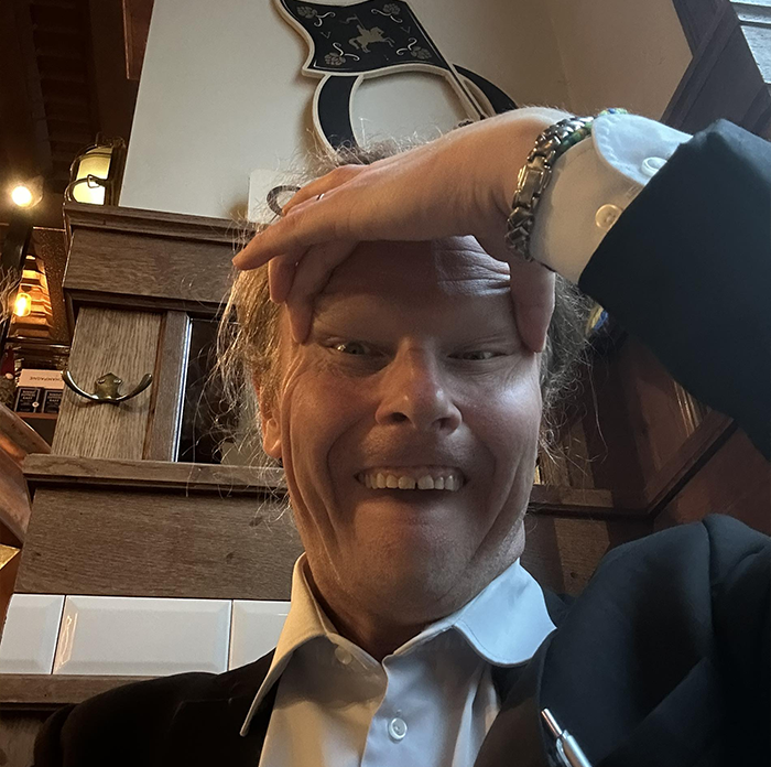 Man in formal attire sitting indoors, illustrating Japan government takes aim at Finland in racist gesture controversy.