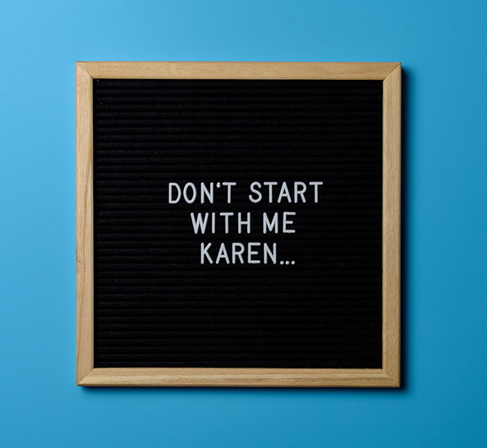 Black felt letter board with wooden frame reads "Don't start with me Karen" on a blue background referencing Karen era and Gen Z trends.