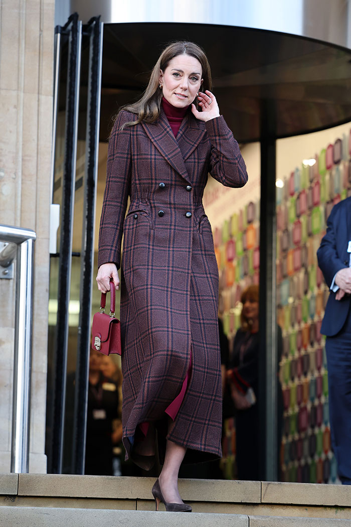Kate Middleton wearing a long plaid coat and heels during Christmas appearance amid scar and cancer conspiracy theories. Kate Middleton wearing a long plaid coat and heels during Christmas appearance amid scar and cancer conspiracy theories.