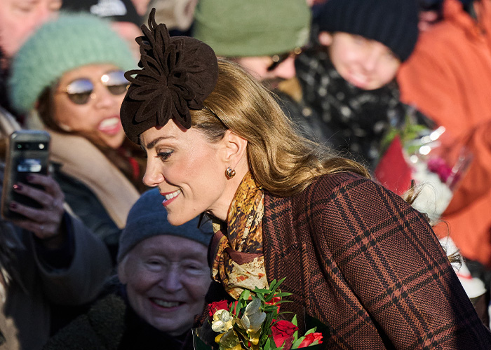 Kate Middleton with a floral headpiece, showing a visible facial scar during a public appearance in winter attire. Kate Middleton with a floral headpiece, showing a visible facial scar during a public appearance in winter attire.