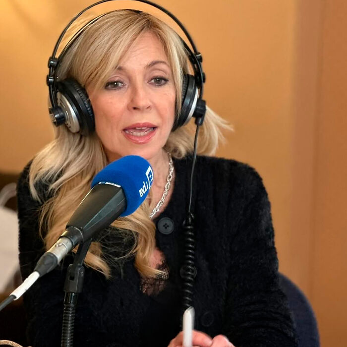 Woman with blonde hair wearing headphones and speaking into a microphone, discussing Kate Middleton&rsquo;s facial scar rumors.