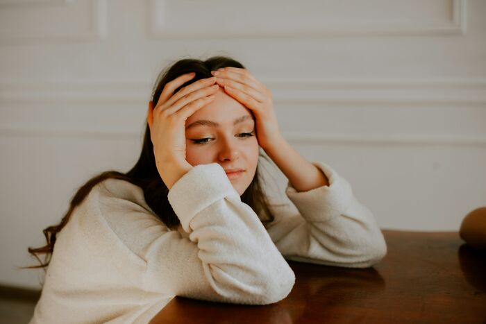 Young woman resting her head on hands, reflecting emotions often revealed in serious relationships with women shared by men.