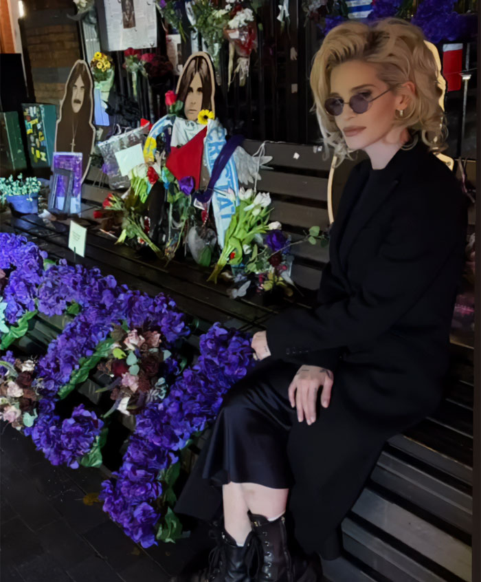 Woman with sunglasses and blonde hair sitting by a memorial adorned with flowers, related to Sharon Osbourne and Kelly’s weight loss news. Woman with sunglasses and blonde hair sitting by a memorial adorned with flowers, related to Sharon Osbourne and Kelly’s weight loss news.