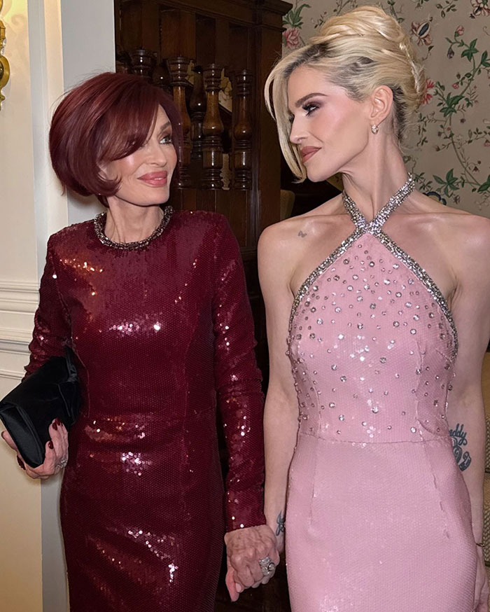 Sharon Osbourne and Kelly Osbourne holding hands, dressed in elegant sequined gowns at an event. Sharon Osbourne and Kelly Osbourne holding hands, dressed in elegant sequined gowns at an event.