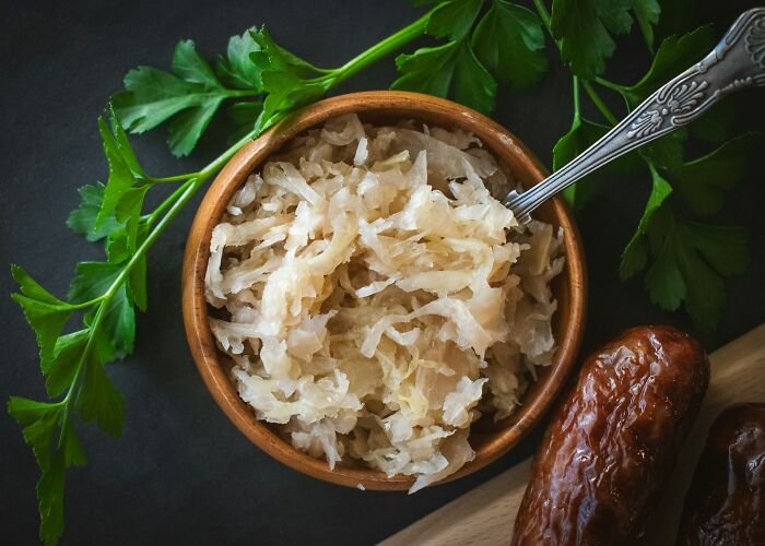 Bowl of sauerkraut with parsley and sausage, illustrating people share historical facts unknown until recently.