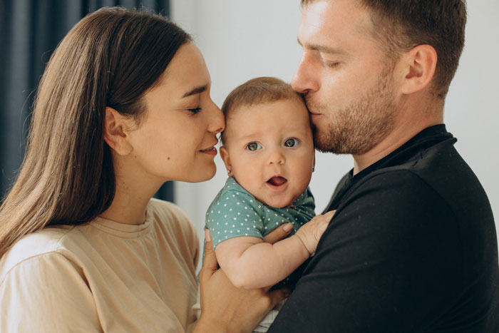 Woman with baby embraced by man, representing sacrifice and empowerment after lifetime of family challenges. Woman with baby embraced by man, representing sacrifice and empowerment after lifetime of family challenges.