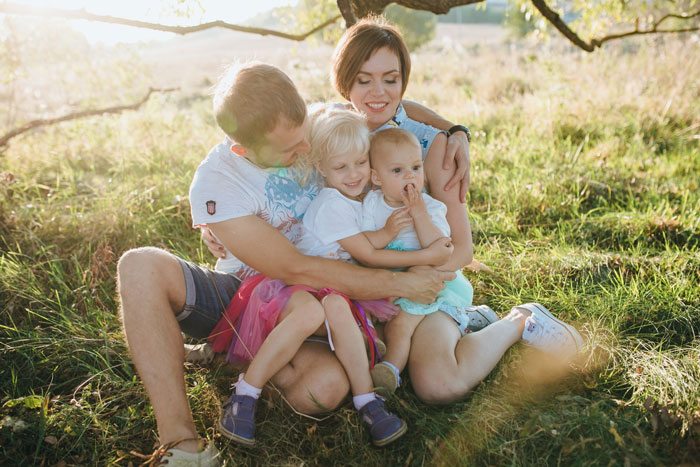 Happy family outdoors celebrating kids custody relationship during a sunny birthday picnic in the park. Happy family outdoors celebrating kids custody relationship during a sunny birthday picnic in the park.
