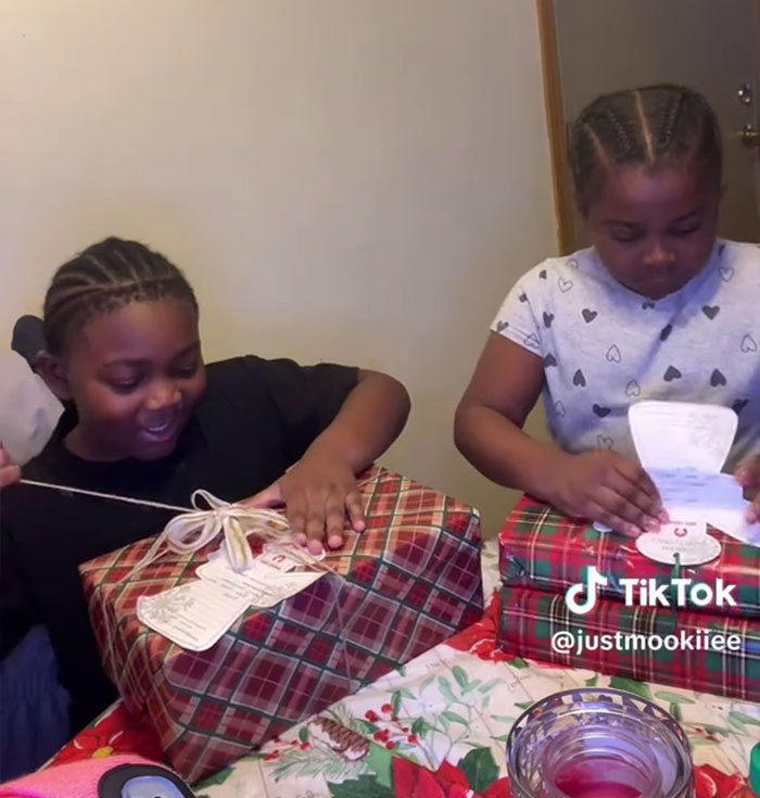 Two children opening Angel Tree gifts at a table, capturing son’s reaction in a viral mom’s video on TikTok. Two children opening Angel Tree gifts at a table, capturing son’s reaction in a viral mom’s video on TikTok.