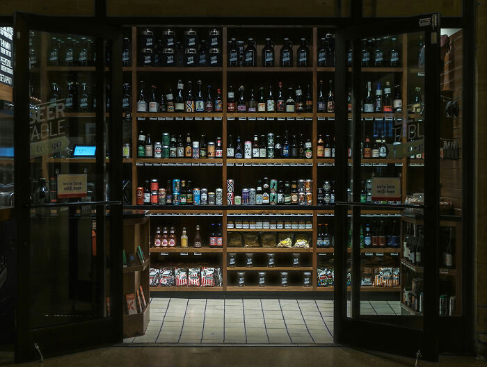 Liquor store shelves filled with various bottles and cans, setting the scene for raccoon raid and bathroom mishap. Liquor store shelves filled with various bottles and cans, setting the scene for raccoon raid and bathroom mishap.