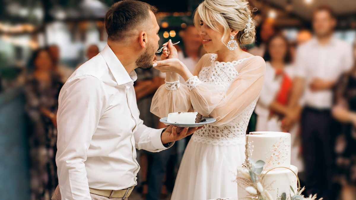 Bride feeding groom cake at wedding reception, symbolizing painful divorce and final straw in a former friendship.