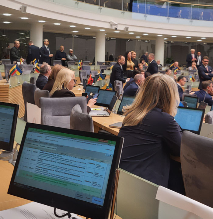 Lithuanian lawmakers in a parliamentary session discussing new legislation involving cat’s consent and national broadcaster head.