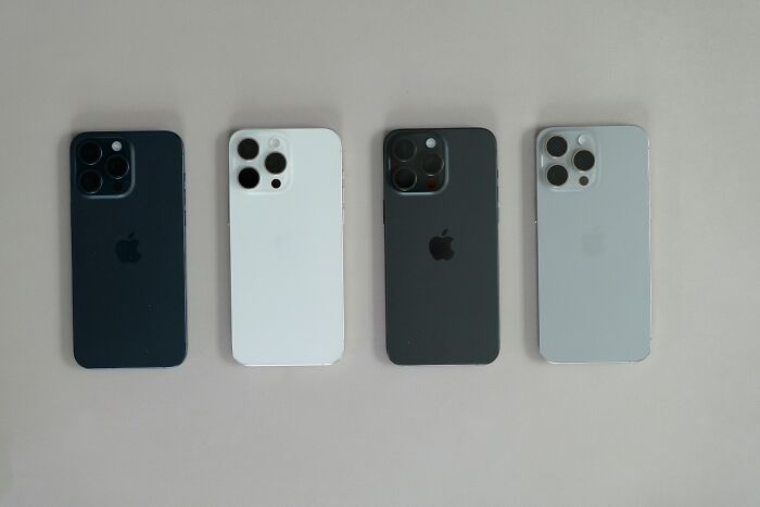 Four lost iPhones in black, white, and gray colors placed side by side on a plain surface.