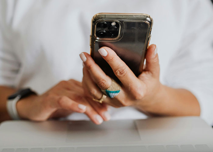Close-up of a person holding a smartphone, highlighting phone dependence over family relationships.