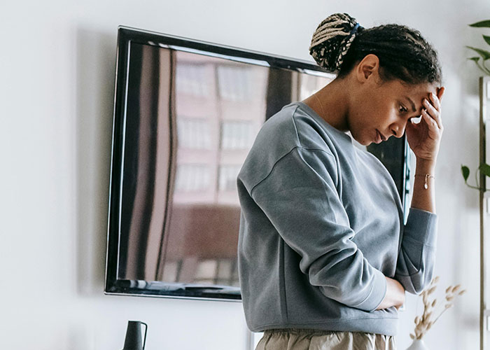 Woman looking distressed at home, illustrating phone dependence affecting family relationships and causing marital issues. Woman looking distressed at home, illustrating phone dependence affecting family relationships and causing marital issues.