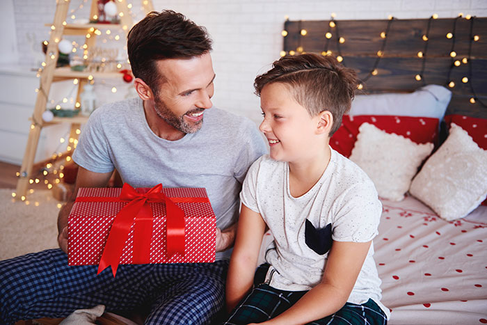 Dad and son sharing a moment with a wrapped gift, highlighting drama involving protecting the son's special present. Dad and son sharing a moment with a wrapped gift, highlighting drama involving protecting the son's special present.