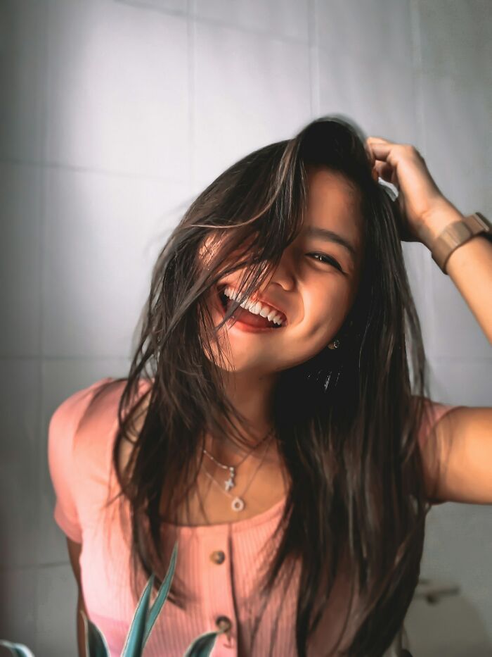 Young woman with long hair smiling happily, illustrating insights men learned about women from serious relationships.