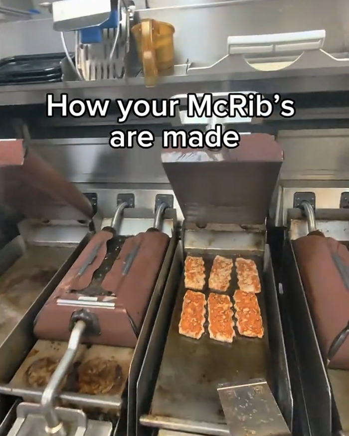 McDonald's worker cooking McRib patties on a grill, showing the process of how McRib is made in the kitchen. McDonald's worker cooking McRib patties on a grill, showing the process of how McRib is made in the kitchen.