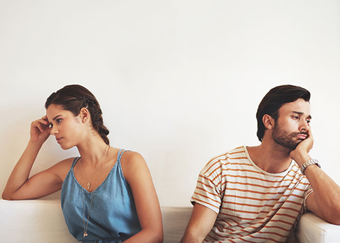 Woman and man sitting apart looking upset, illustrating relationship issues after boyfriend salts entire pot of chili Woman and man sitting apart looking upset, illustrating relationship issues after boyfriend salts entire pot of chili