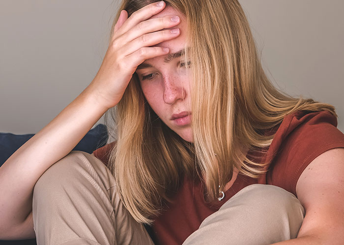 Young woman looking distressed and upset, reflecting a tense family situation involving sister and parents at Christmas. Young woman looking distressed and upset, reflecting a tense family situation involving sister and parents at Christmas.