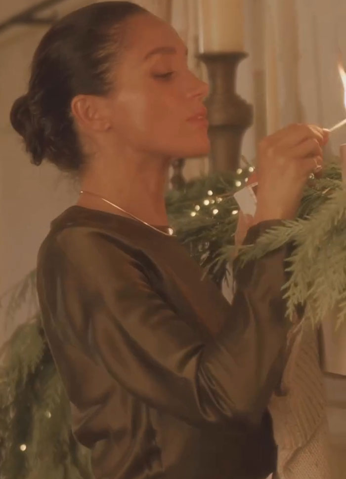 Meghan Markle lighting a candle by Christmas decorations, linked to Prince Harry split rumors during holiday season. Meghan Markle lighting a candle by Christmas decorations, linked to Prince Harry split rumors during holiday season.