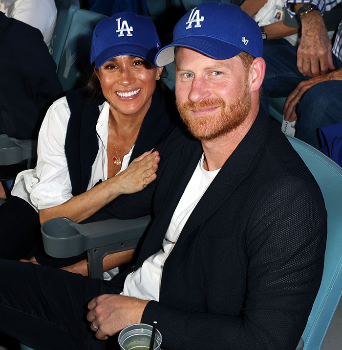 Prince Harry and Meghan Markle wearing matching LA caps, smiling together at an event amid holiday snap manipulation claims. Prince Harry and Meghan Markle wearing matching LA caps, smiling together at an event amid holiday snap manipulation claims.