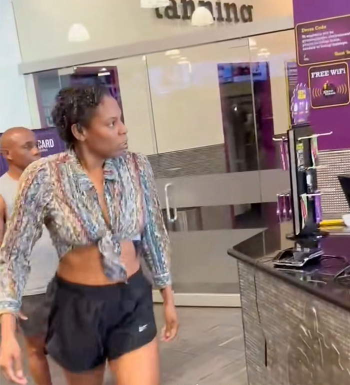 Woman in patterned top and black shorts inside gym, involved in Miami gym Karen punching employee incident.