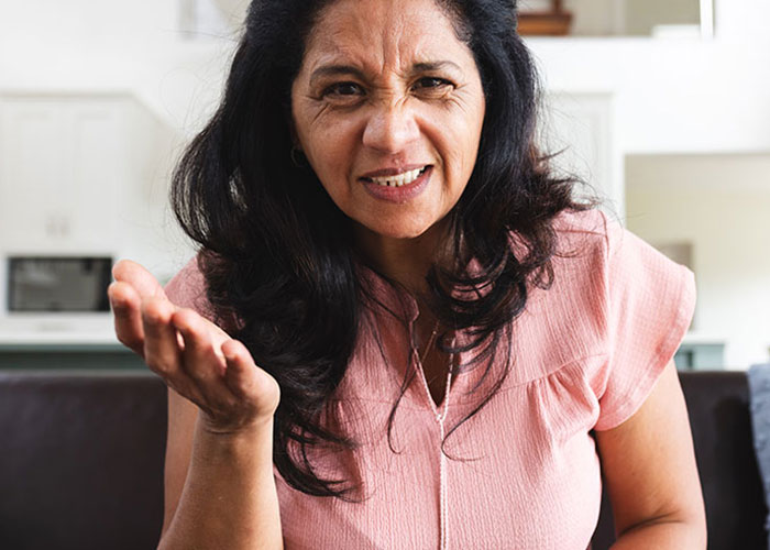 Woman expressing frustration indoors, illustrating tension when reheating pizza leftovers for MIL during Christmas visit. Woman expressing frustration indoors, illustrating tension when reheating pizza leftovers for MIL during Christmas visit.