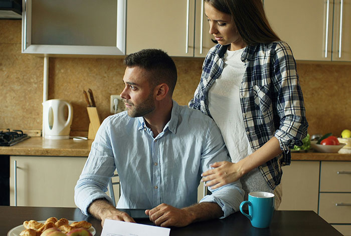 A woman confronts a man at the kitchen table, reflecting tension related to unhinged MIL losing her job and promotion news. A woman confronts a man at the kitchen table, reflecting tension related to unhinged MIL losing her job and promotion news.