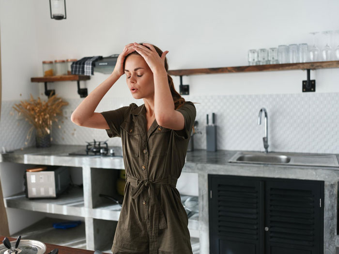 Woman in kitchen looking stressed, possibly preparing Christmas dinner for mom and daughter gathering. Woman in kitchen looking stressed, possibly preparing Christmas dinner for mom and daughter gathering.