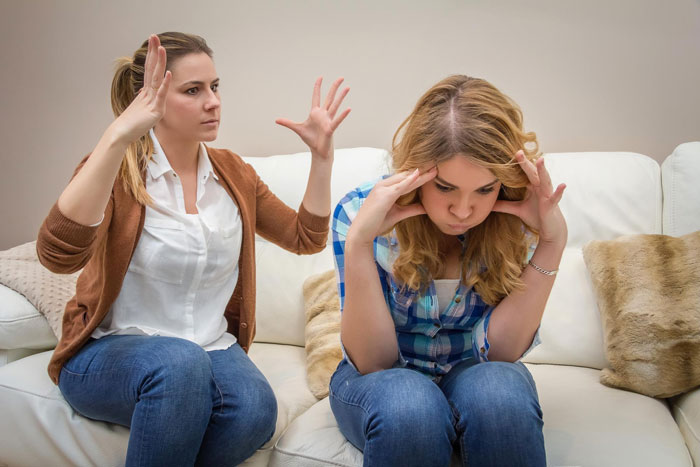 Woman frustrated and stressed as mom angrily gestures, illustrating tension linked to mom-nuked-credit-score issues at home.