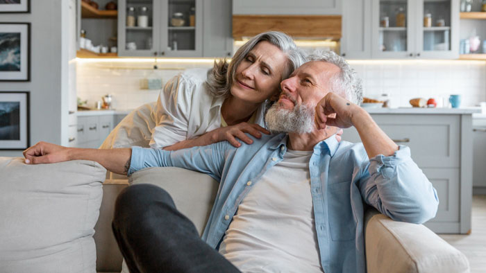 Older couple relaxing in a modern kitchen, highlighting parents who abandoned their daughter and faced her refusal to help. Older couple relaxing in a modern kitchen, highlighting parents who abandoned their daughter and faced her refusal to help.