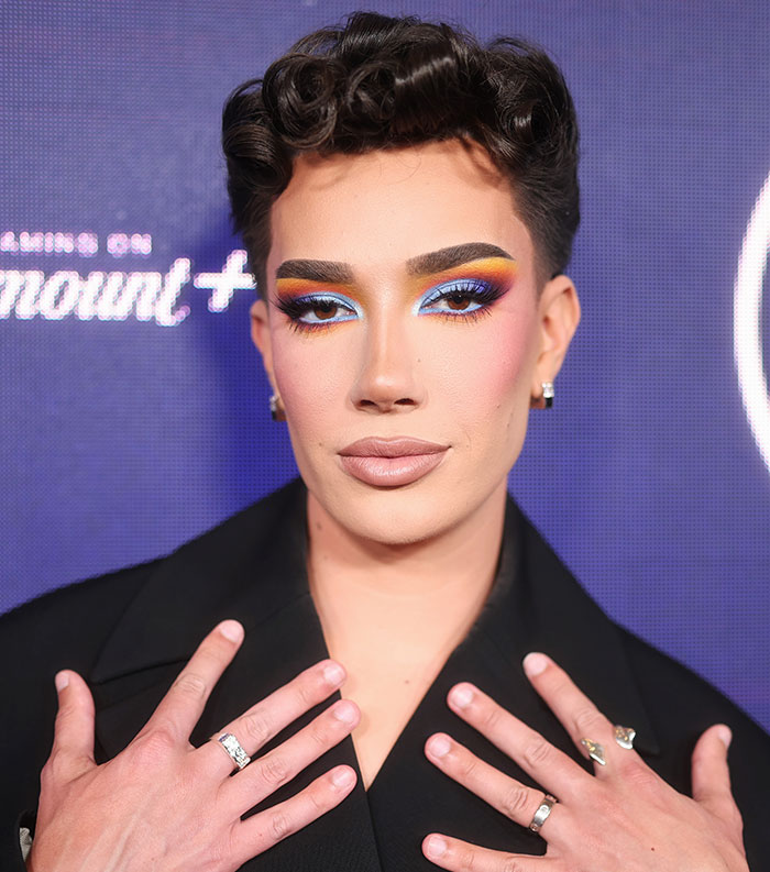 Person with colorful eye makeup and styled hair posing at an event about most disliked celebrities of 2025.