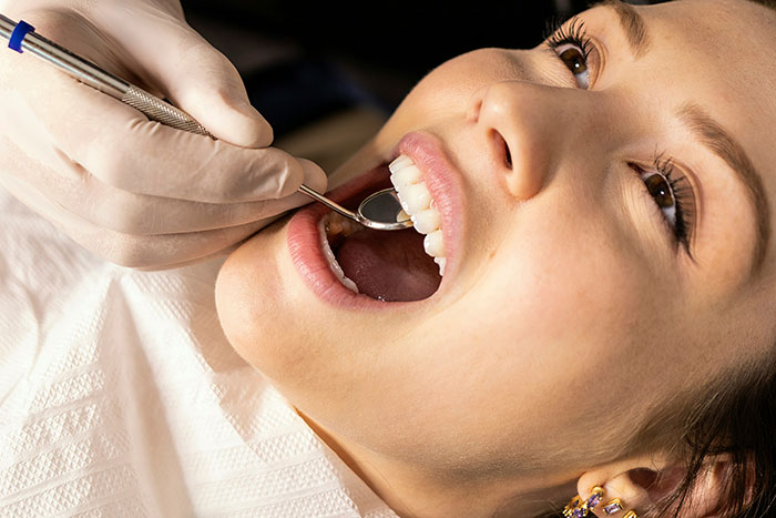 Dentist examining patient's teeth with dental tools, illustrating doctors sharing wrong self-diagnoses examples.