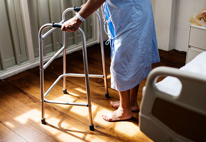 Patient using a walker in a hospital room highlighting common issues with wrong self-diagnoses by doctors.