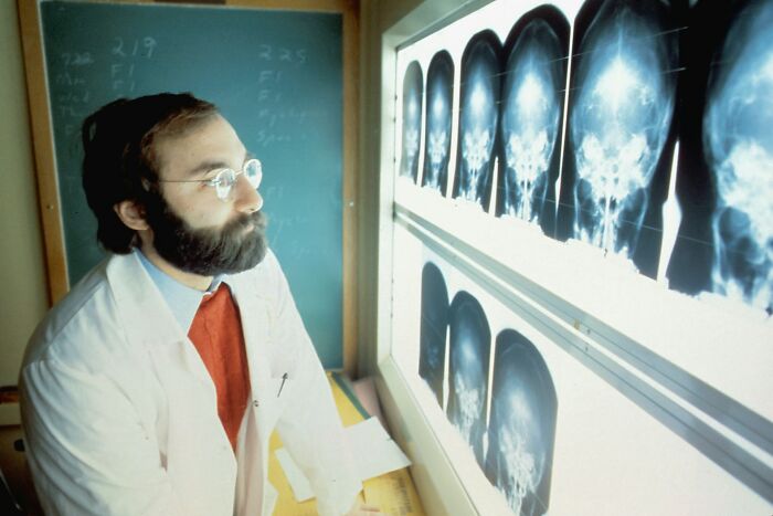 Doctor in white coat examining X-rays on a light panel, illustrating facts that sound made up but are actually true.