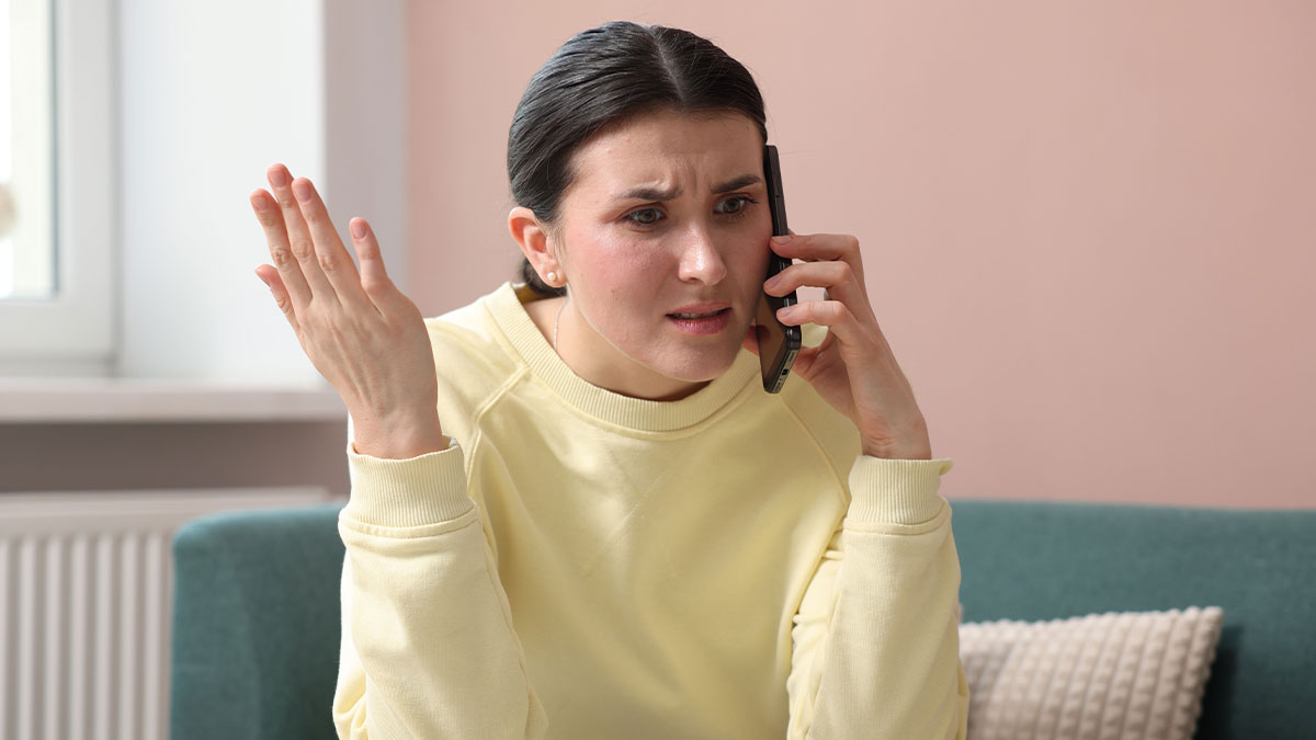 Woman frustrated on phone call discussing family catering to her allergies and grandkids in a home setting